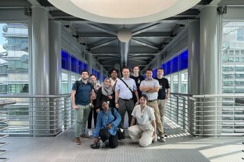 A group of M.TBVU students and professors pose for a photo on the skybridge between the two Petronas Towers in Kuala Lumpur