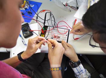 Students work on a circuitboard together