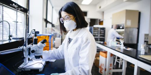 A Ph.D. student conducts air quality research in a lab