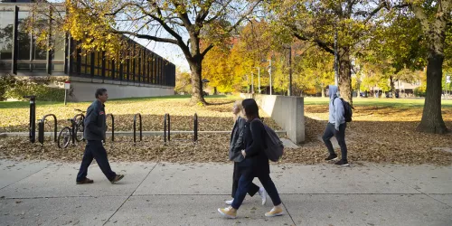 Outdoor photo of students walking on campus in autumn, showing Galvin library