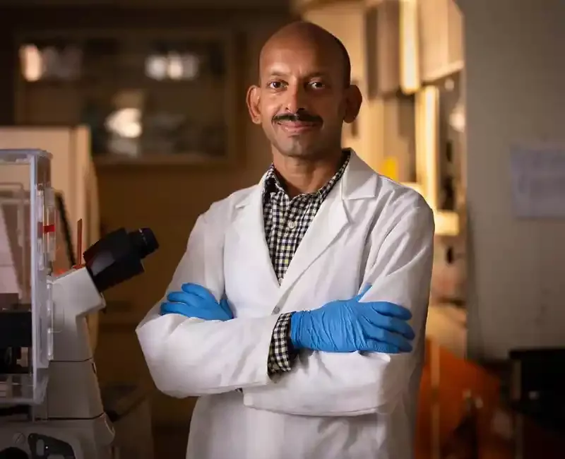 Abhinav Bhushan in lab coat standing in lab